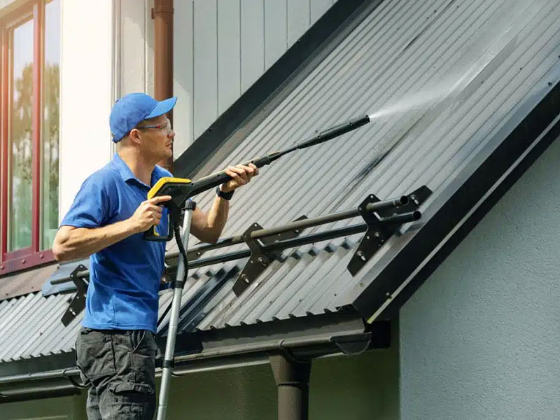 Man Cleaning roof with high pressure washer